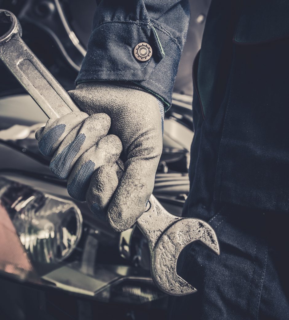 Fixing the Car Concept. Mechanic with Large Wrench is About To Start His Car Maintenance and Fix Work.